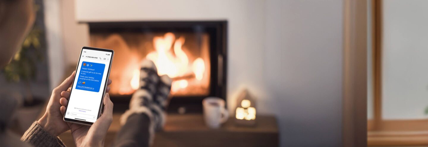 F&A member looking at the mobile app in front of the fire.