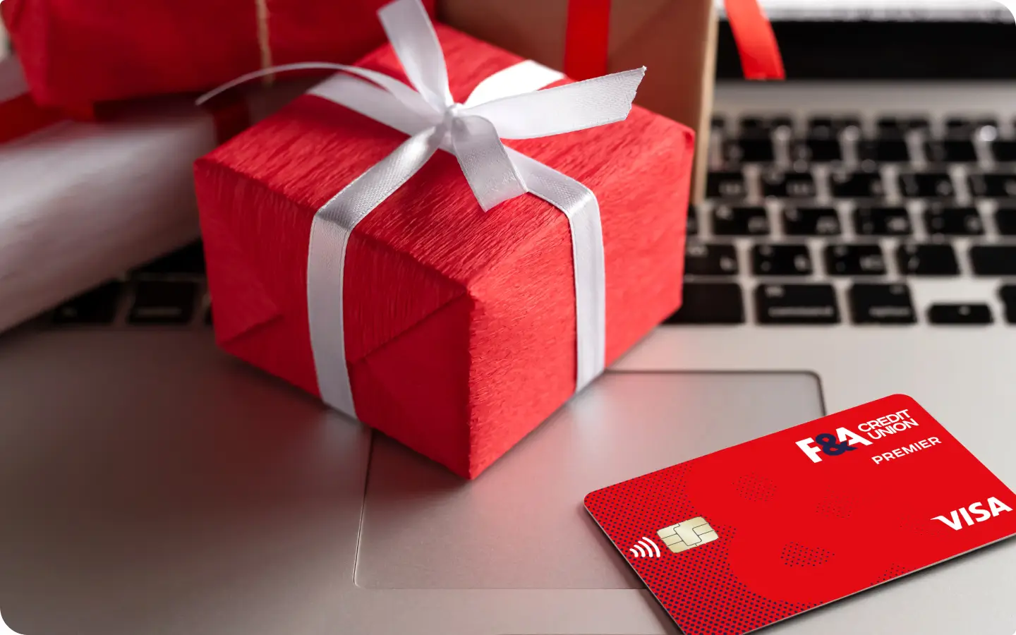 Picture of a credit card and gift next to a laptop.
